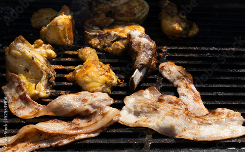 Aerial shot of grilled meat cooking on a wrought iron grill