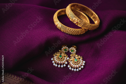 Fotótapéta Golden bangles with Gold earrings on a purple saree background