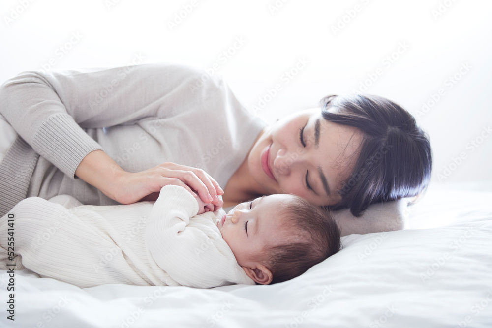 眠る赤ちゃんと添い寝をする母親 眠る赤ちゃんと添い寝をする母親