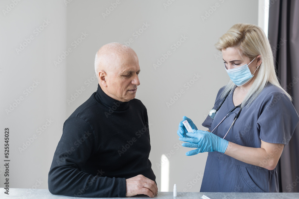 Obraz premium Nurse performing a coronavirus pcr test on an elderly man in his home