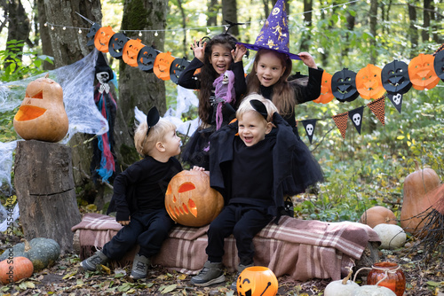 happy kids in halloween costumes having fun in halloween decorations outdoor