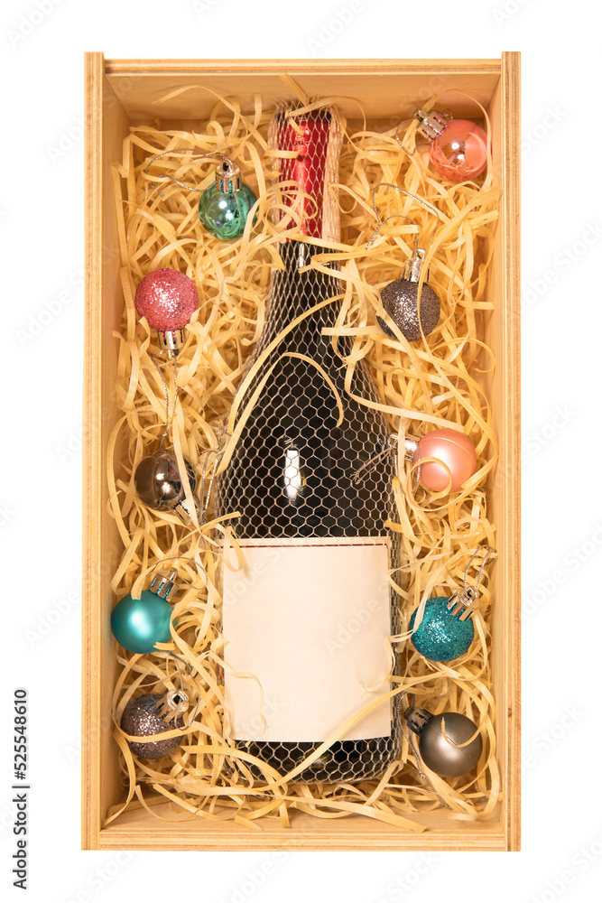 Bottle of champagne with copy space label in wooden box with baubles isolated on white background, Christmas gift box concept. Bottle of champagne with copy space label in wooden box with baubles isolated on white background, Christmas gift box concept.