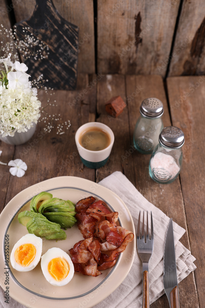 Breakfast with bacon, eggs and coffee on a wooden table