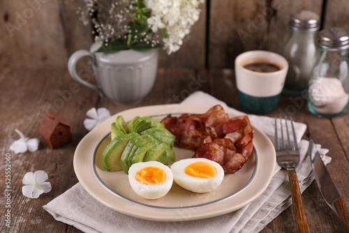 Breakfast with bacon  eggs and coffee on a wooden table