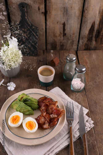 Breakfast with bacon, eggs and coffee on a wooden table