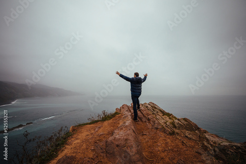 Happy man with open arms near the sea