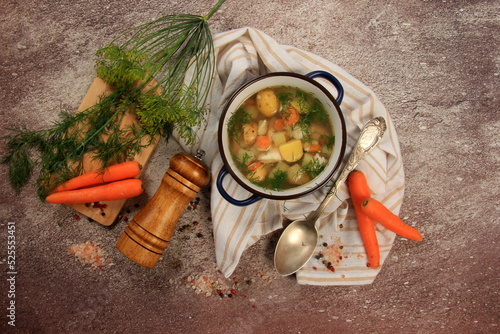 Fresh fish soup with vegetables in bowl on dark background, top view
