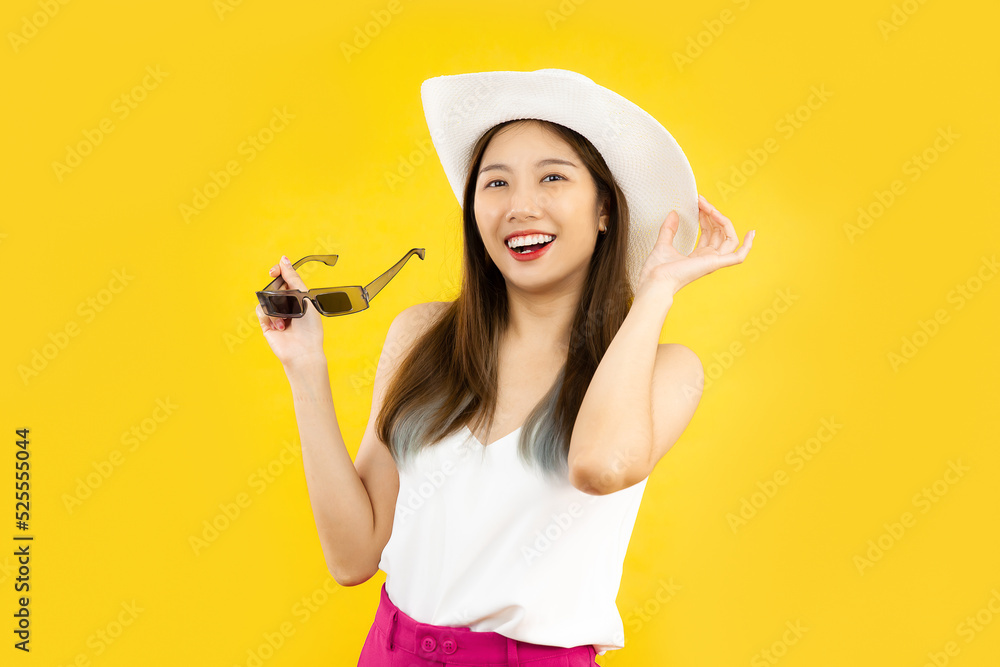 portrait of young asian woman smiling in trendy summer clothes posing isolated on yellow wall in studio. travel airlines concept portrait of young asian woman smiling in trendy summer clothes posing isolated on yellow wall in studio. travel airlines concept