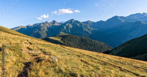 Majestic scenery of rough mountain ridge near grassy hills photo