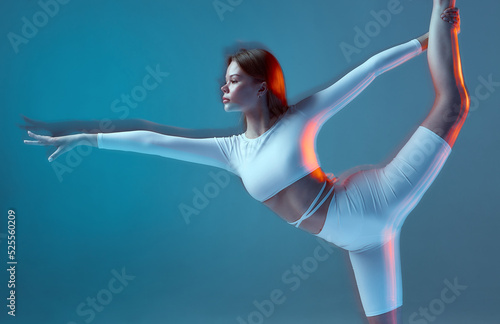 Pilates studio advertising. Flexible girl training, stretching. Ballerina performs ballet dance elements. Long exposure