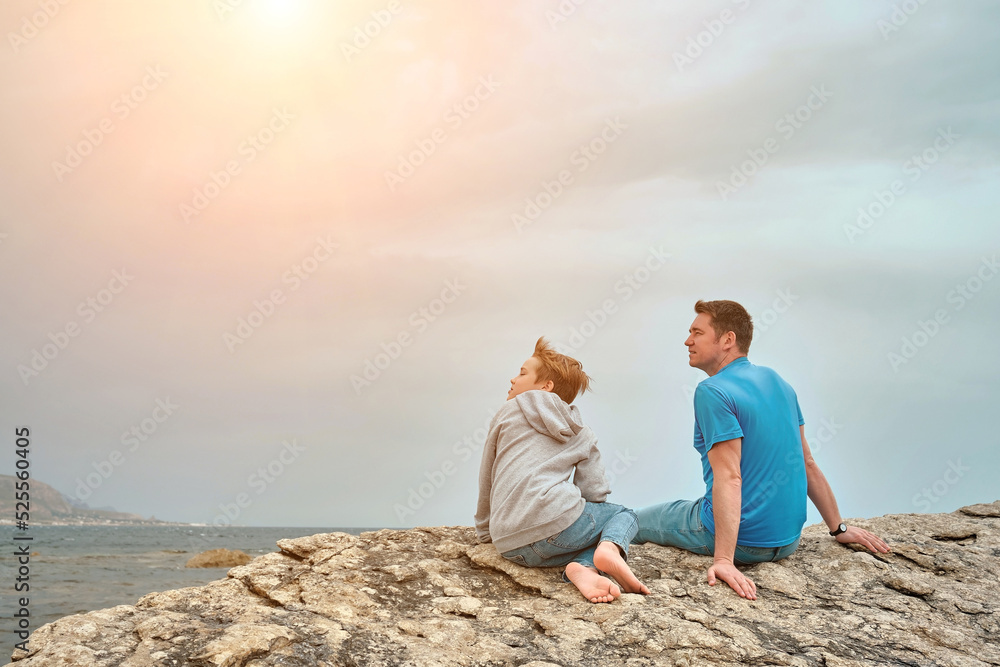 Happy family, father and son bonding, sitting on stone by the sea looking at view enjoying summer vacation. Togetherness Friendly concept
Happy family, father and son bonding, sitting on stone by the sea looking at view enjoying summer vacation. Togetherness Friendly concept