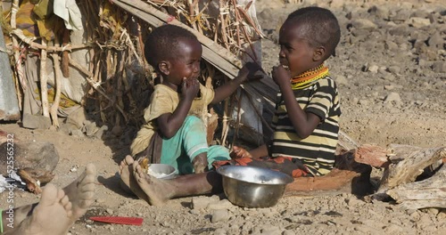 Close-up.Malnourished children due to extreme poverty, drought and climate change. Eating maize porridge infront of their dwelling.Kenya photo