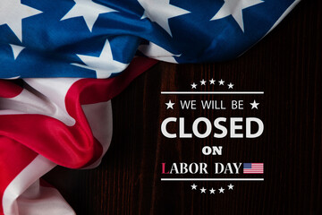 Labor Day Background Design. American flag on a wooden table with a message. We will be Closed on Labor Day.