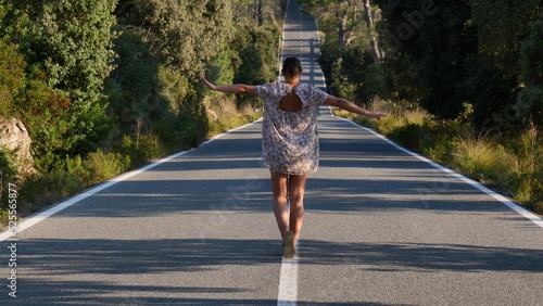 Mujer andando sobre lineas de carretera