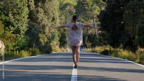 Mujer andando sobre lineas de carretera