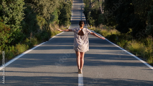 Mujer andando sobre lineas de carretera
