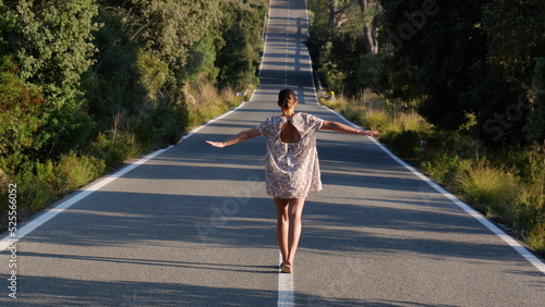 Mujer andando sobre lineas de carretera