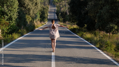 Mujer andando sobre lineas de carretera