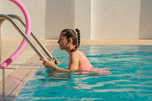 A girl in a swimsuit comes out of the pool