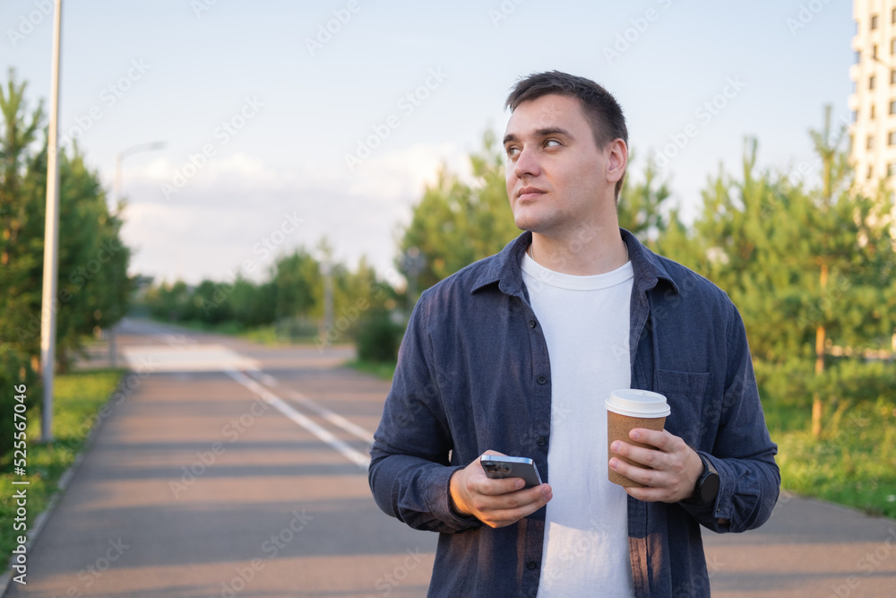 a businessman walking in a city park with a cup of coffee. a happy man walking down the street in the daytime. a businessman walking in a city park with a cup of coffee. a happy man walking down the street in the daytime.