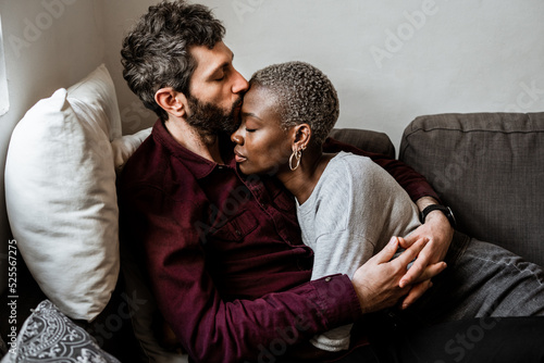 Young multiethnic couple resting on sofa