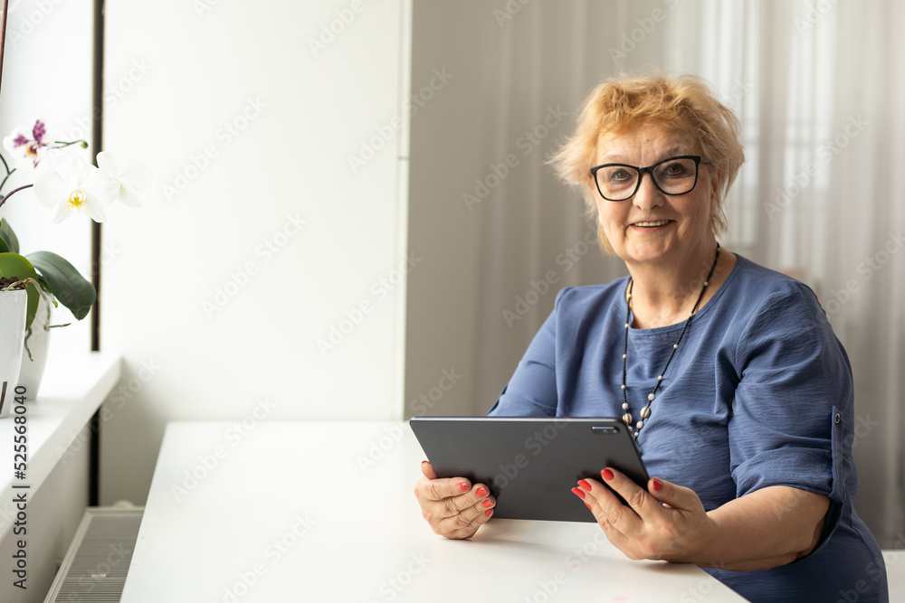 Authentic shot of a happy grandmother is making a video call to relatives with a laptop at home. Concept of technology, modern generation,family, connection, authenticity Authentic shot of a happy grandmother is making a video call to relatives with a laptop at home. Concept of technology, modern generation,family, connection, authenticity