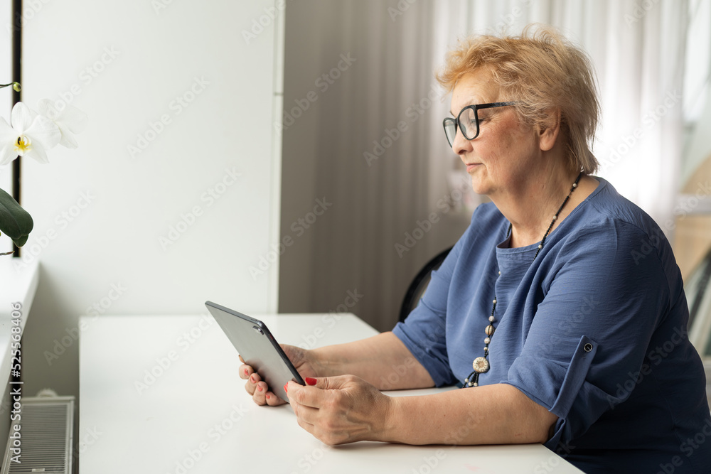 Senior woman using digital tablet at home. The use of technology by the elderly