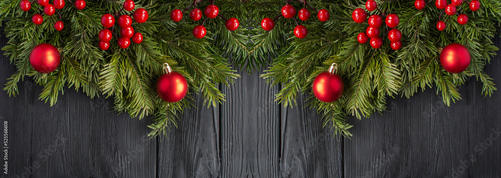 Christmas banner with spruce branches and red bead on the black wooden background. Copy space. Christmas banner with spruce branches and red bead on the black wooden background. Copy space.