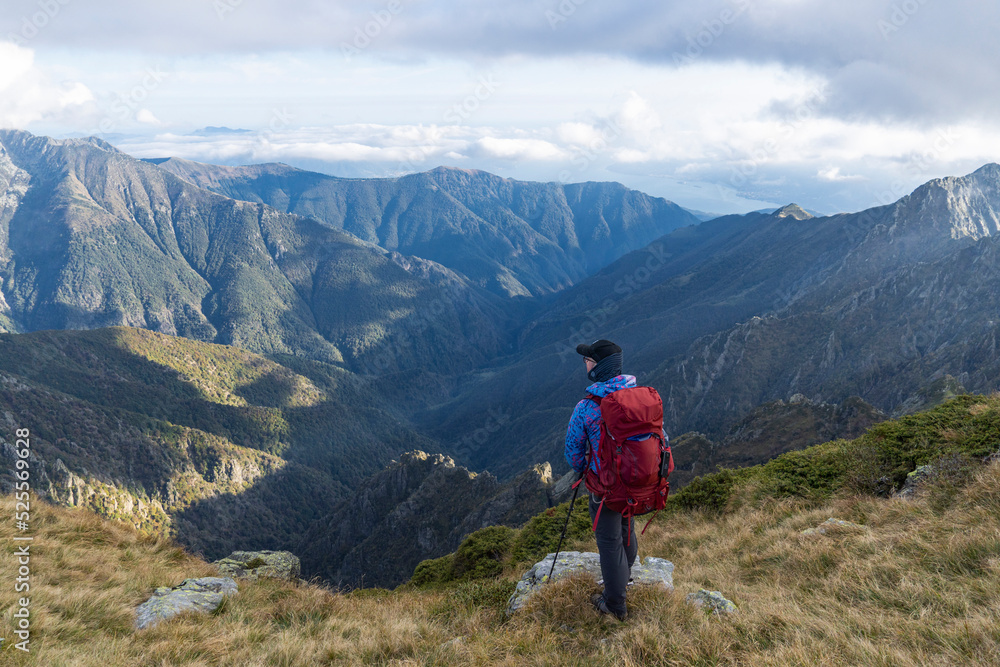 Hiker on ridge looking into vast valley in Val Grande, Italy Hiker on ridge looking into vast valley in Val Grande, Italy