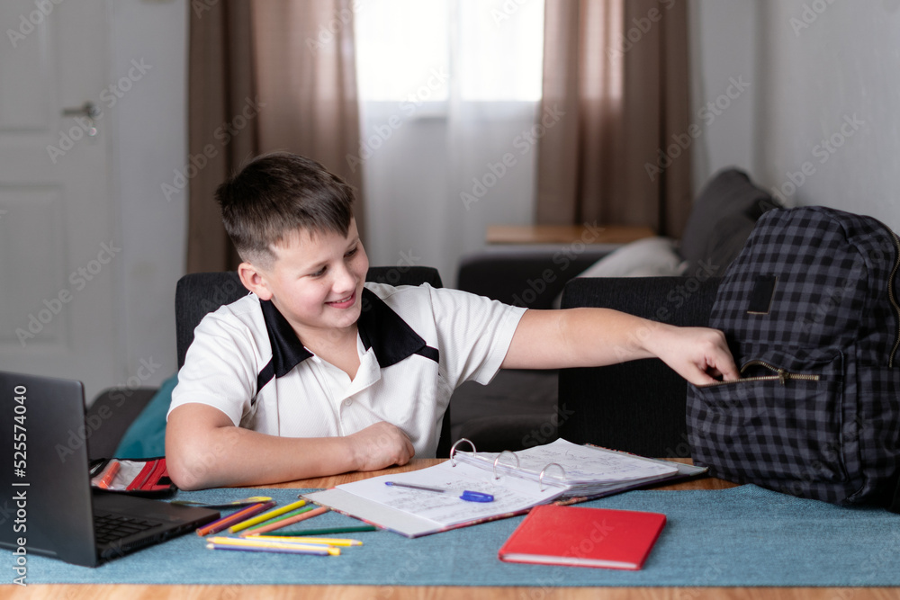 Caucasian kid smiling and taking something from his schoolbag Caucasian kid smiling and taking something from his schoolbag