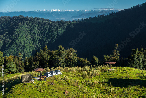 A wide angle shot of Camping in the hills of Himalayan region of Uttarakhand, India with visible Gomukh Glacier peaks in the background. photo