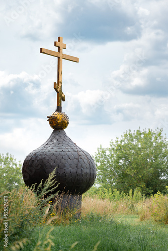 Fotografija Old russsian chirch tip with golden cross separate bring down on ground and gras