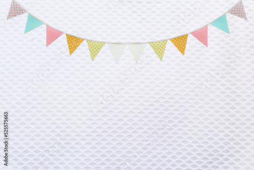 Colorful flag garland on white fabric texture background, party and festive concept background