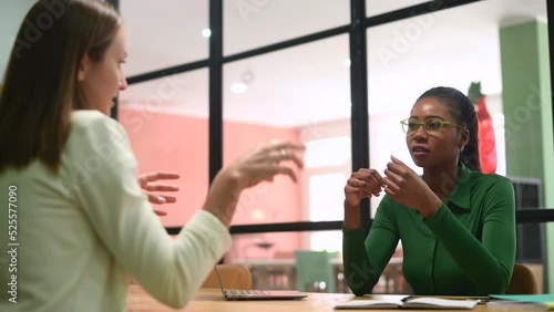 Work team brainstorming sitting in the modern boardroom, coworkers discussing business tasks during morning meeting, concentrated african-american female employee listening while colleague talking