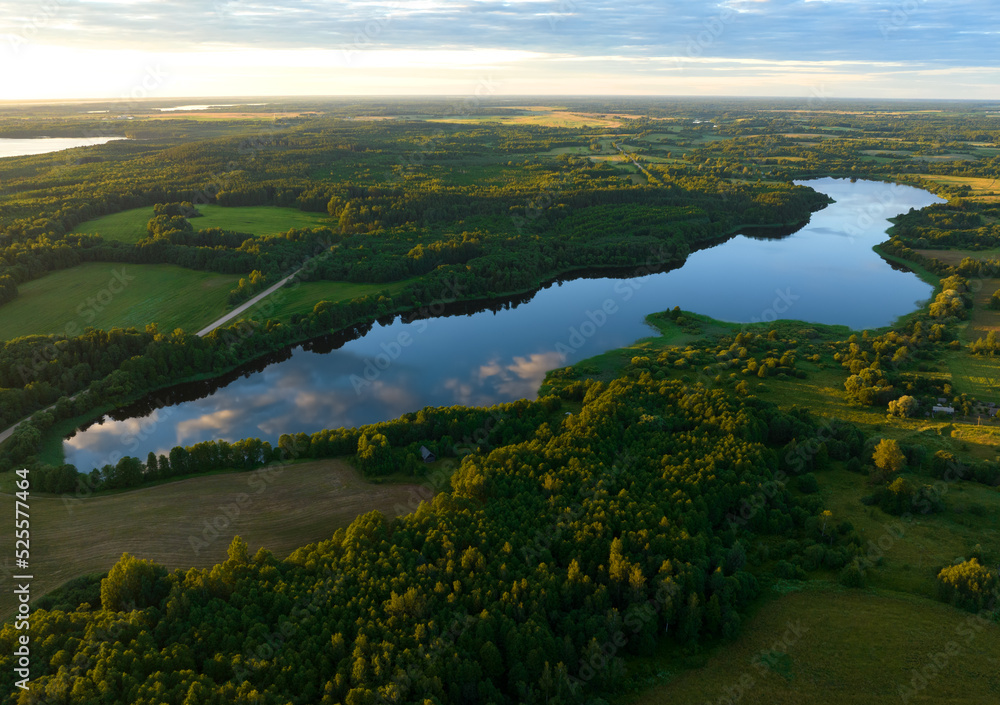 Lake in forest at sunset. Sunset over the forest lake. Rural landscape. Village at lake, aerial view. Pond in forest on sunset, aerial view. Wet Pond water. Country houses at river in countryside.