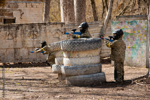several children with machine guns and paintball masks play war