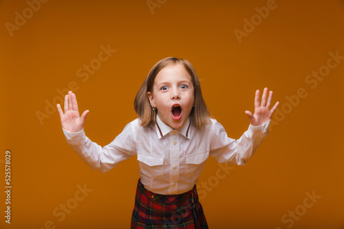 What a surprise. Surprised child schoolgirl on a yellow background. School education. "Back to school"