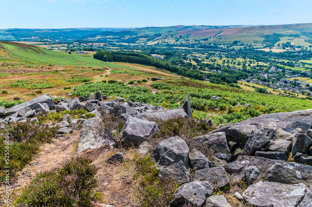 A view towards Bamford over rock outcrops on the top of the Bamford Edge escarpment in summertime