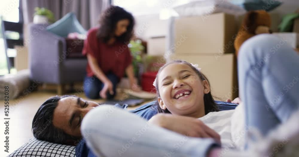 Father, family and bonding in real estate house of a happy daughter with dad laughing in the living room on the floor. Girl playing with parent, smile and laugh moving into a new home with mother. Father, family and bonding in real estate house of a happy daughter with dad laughing in the living room on the floor. Girl playing with parent, smile and laugh moving into a new home with mother.