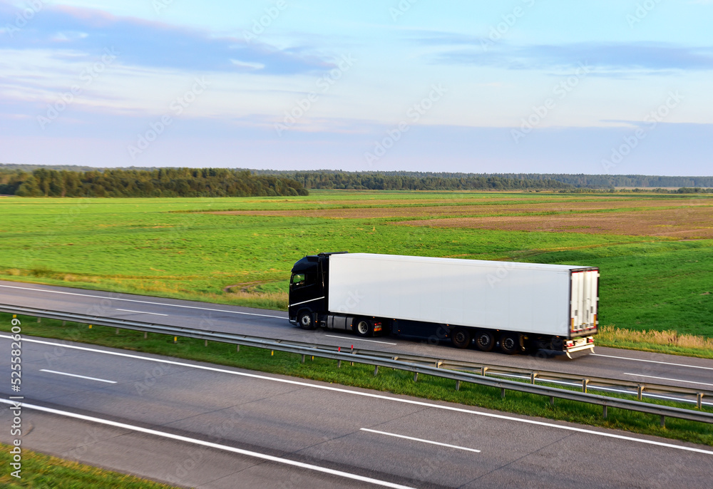 Truck with semi-trailer driving on highway on sunset. Goods delivery by ...
