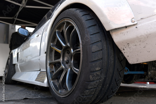 Tires of race car for driving. Drag and drift car with lower-profile tire. Racing low profile tyre with brake disc. Alloy wheel with calipers and racing brakes of the sport cars. Tyres background..