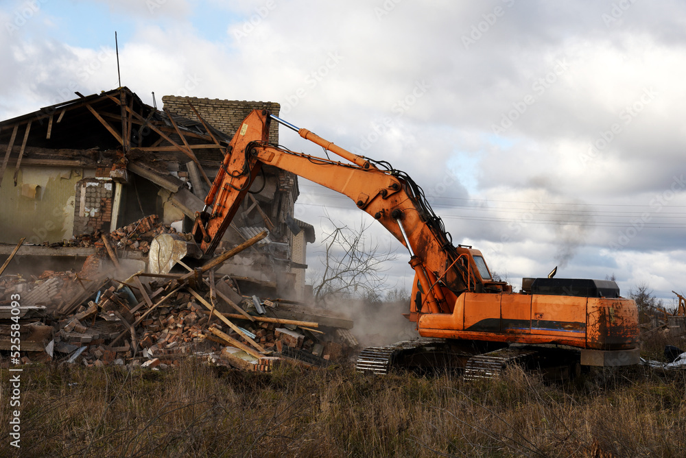 Excavator during demolition the house in the rural. Renovation old home