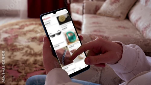 A teenager looks at goods in online store on a smartphone.