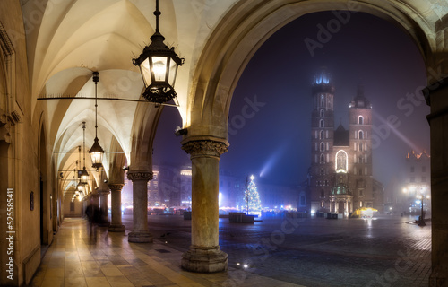 A foggy, autumn night on the main square in Krakow, the St. Mary's Basilica and the cloth hall. Mglista, jesienna noc na rynku głównym w Krakowie, z widokiem na Bazylikę mariacką i sukiennice