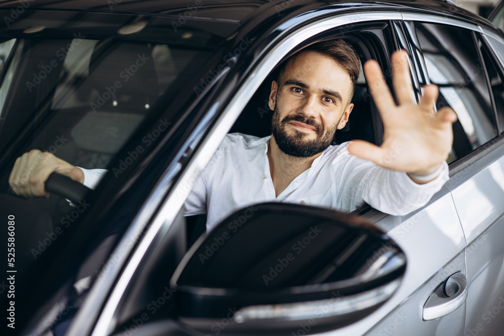 Man sitting in car in a car showroom Man sitting in car in a car showroom