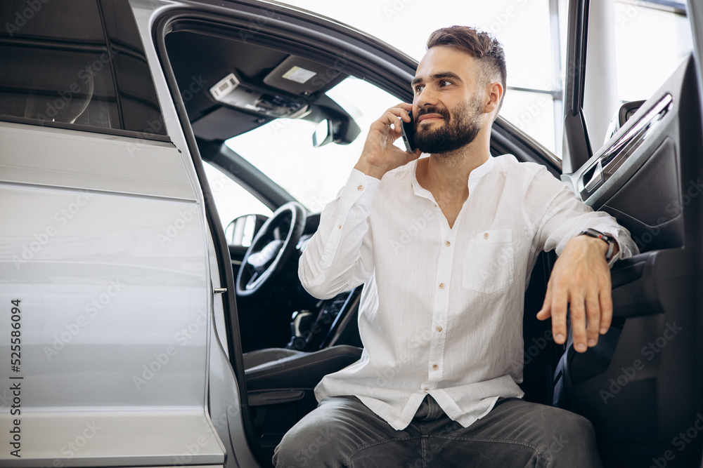 Man talking on the phone in a car showroom Man talking on the phone in a car showroom