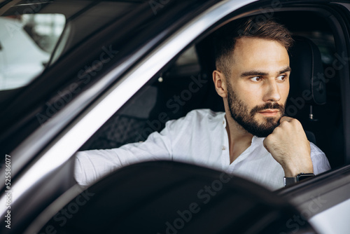 Man sitting in car in a car showroom © Petro