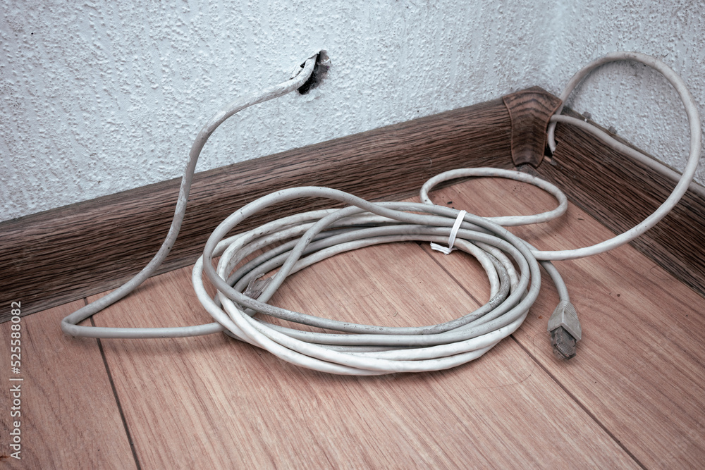 Rolled up cable on the dirty floor. The disconnected
