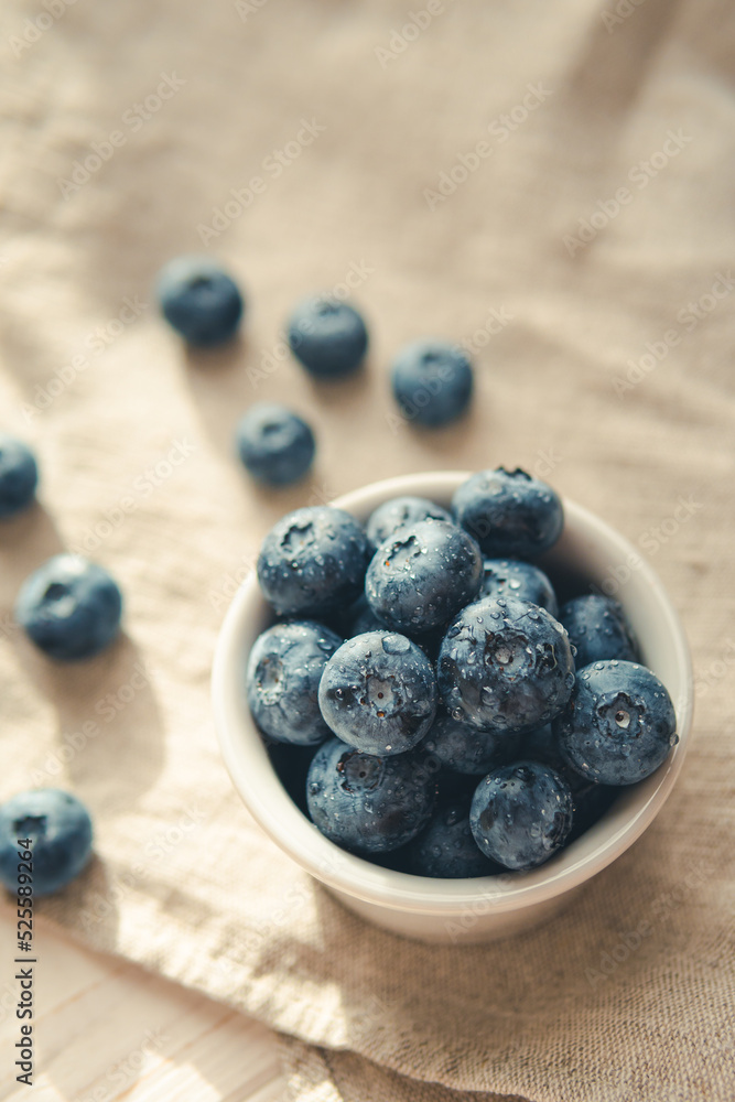 Freshly picked juicy blueberries in the bowl on wooden background, close up. Blueberries background. Concept of healthy nutrition, organic food. Vegan and vegetarian Freshly picked juicy blueberries in the bowl on wooden background, close up. Blueberries background. Concept of healthy nutrition, organic food. Vegan and vegetarian