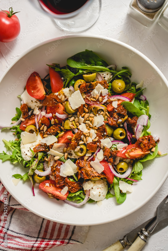 Tasty dried tomatoes salad with fresh vegetables mix and mozzarella cheese served with toasts Tasty dried tomatoes salad with fresh vegetables mix and mozzarella cheese served with toasts